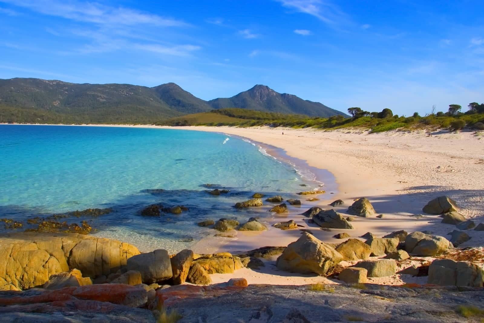 plage de sable avec des montagnes derrière