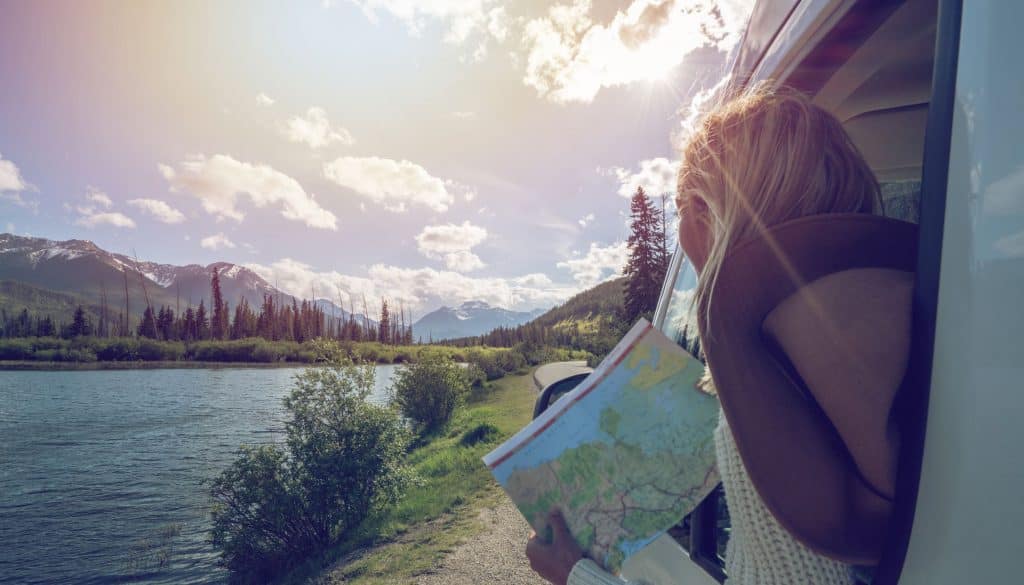 Jeune femme tenant une carte et explorant le Canada 