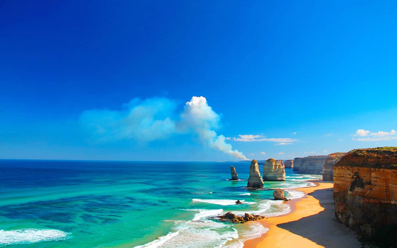 mer turquoise avec une plage de sable et des rochers