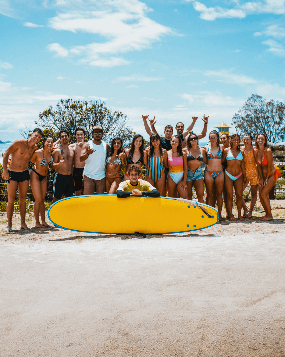 Grupo de jóvenes en traje de baño sonriendo y posando juntos al aire libre en la playa australiana